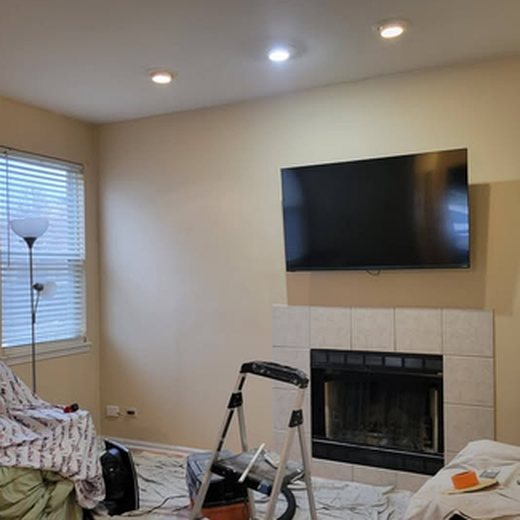 Living room before: beige walls, ladder and drop cloths